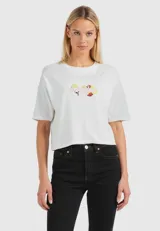 Remera blanca de corte cropped y mangas cortas, con cuello redondo y estampado frontal con la frase "My Orchard Club" y dibujos de frutas.