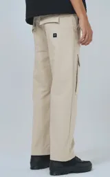 Pantalón cargo color beige con bolsillos laterales con solapa y etiqueta con texto en una de ellas.
