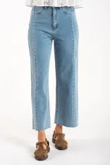 Jean de mezclilla azul claro, tiro medio, corte recto con leve campana al tobillo. Presenta costuras verticales marcadas en el frente y en los laterales de las piernas, y terminación deshilachada en el ruedo.