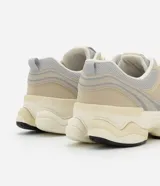 Championes urbanos de running color beige y gris con recortes de cuero sintético y detalles reflectantes.