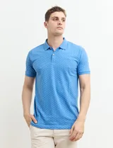 Chomba celeste con estampado de lunares blancos, cuello clásico y mangas cortas.