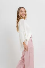 Sweater amplio de tejido liviano color blanco, con textura semi traslúcida, mangas amplias estilo murciélago, escote redondo y terminaciones suaves.