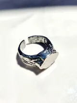 Anillo de acero inoxidable plateado con diseño tipo piedra, adaptable con un diámetro de 19 mm.