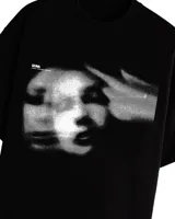 Remera negra con efecto gastado y estampado frontal de una cara y una mano apuntando.