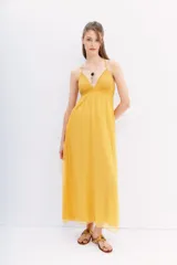 Vestido largo amarillo de gasa con breteles regulables que se cruzan en la espalda y bordado de mostacillas a tono.