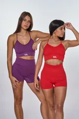 Conjunto deportivo color violeta compuesto por un top con tiras cruzadas en la espalda y un short ajustado con frunce en la parte trasera.
