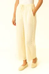 Pantalón color crema de lino y viscosa, corte ancho, tiro alto y detalles de broderie.