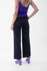 Pantalón negro de corte palazzo con lazo en la cintura.