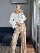 Pantalón palazzo blanco con estampado de motivos tribales en negro, cintura elástica y bolsillos laterales. Talle único.