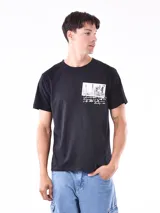 Remera negra de corte regular con estampado de fotos y texto en el pecho.