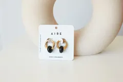 Aros de acero quirúrgico hipoalergénico con piedras naturales azules. Diseño de aro con dije circular colgante.