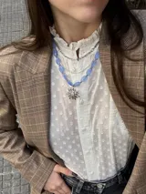 Collar corto de cuentas de cristal checo color celeste, con dije de sol plateado con circonitas.