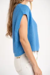 Chaleco de punto color beige con lurex, de corte recto y mangas cortas. Tejido calado con pequeños agujeros.