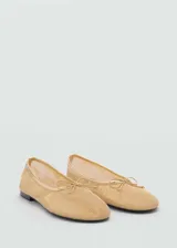 Zapato tipo bailarina color dorado, con tejido de malla y lazo decorativo en la punta.