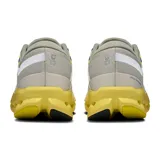 Championes de running On Cloudsurfer 2, color gris claro con detalles en amarillo y blanco.