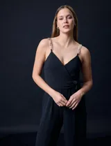 Enterito negro de crepe con escote en V cruzado, cintura elastizada, espalda en punto smock y tirantes con detalle de cadenas.