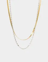 Collar corto de metal dorado y plateado con tres cadenas de diferentes diseños.