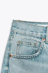 Pantalón de jean azul de corte wide leg, tiro alto y largo hasta el tobillo.