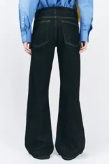 Jeans de tiro bajo con cintura con trabillas, cinco bolsillos, pespuntes marcados a contraste y pierna ancha.