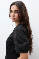 Remera negra de algodón con cuello redondo y mangas cortas abullonadas.