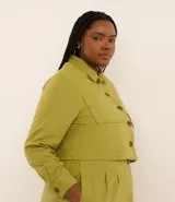 Campera corta color verde oliva, confeccionada en viscolino, con cuello inglés, abotonada adelante, bolsillos y manga larga ajustada.