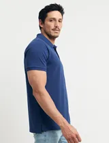 Chomba celeste con estampado de lunares blancos, cuello clásico y mangas cortas.