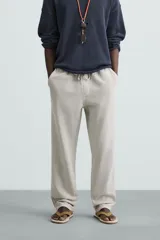 Pantalón color arena de corte recto, confeccionado en tejido de algodón y lino. Cuenta con cintura elástica ajustable con cordón, bolsillos delanteros y traseros de parche.