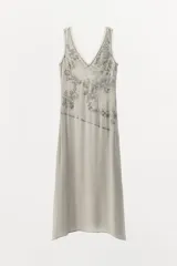 Vestido midi gris con estampado floral y abalorios, escote en V y tirantes anchos.