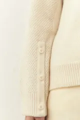 Cárdigan marrón de tejido de punto industrial con escote en V, combinación de puntos y botones en las mangas.