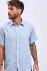 Camisa celeste de lino, de corte clásico, manga corta y cuello italiano.