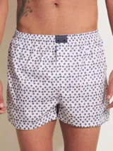 Bóxer de algodón blanco con estampado de flores pequeñas color celeste, con cintura elástica y logo de la marca en el centro.