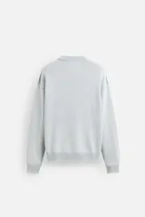 Sweater negro de algodón con cuello redondo y mangas largas. Tiene un acabado lavado con efecto desgastado y rib en cuello, puños y bajo.