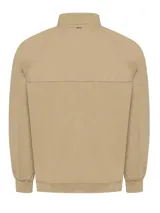 Campera bomber color beige de algodón orgánico con spandex, corte regular, cuello, puños y pretina acanalados, cierre frontal, bolsillos delanteros con solapa y broches ocultos, bolsillos internos y forro de franela.