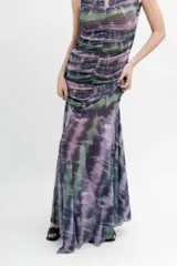 Vestido midi de microtul estampado tipo batik en tonos lavanda, verde y negro. Diseño ajustado con frunces y forro en todo el cuerpo. Falda transparente con terminación en picos.