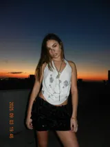 Top blanco con estampado floral plateado, escote halter y cierre frontal con cordones.