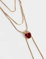 Collar largo multicadena dorada con dije de corazón rojo con strass y cierre de mosquetón.