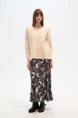 Sweater blanco liso, de corte holgado, con cuello a la base y broches decorativos en los laterales.