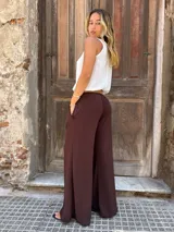 Pantalón marrón de corte palazzo con cintura alta y cinturón marrón.