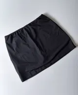 Minifalda negra con short interno y cintura elástica.