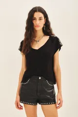 Remera negra de viscosa con escote en V, manga corta y bordado de canutillos y mostacillas color peltre en los hombros.
