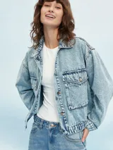 Campera de jean celeste con efecto lavado, corte cropped, cuello camisero, cierre frontal con botones metálicos, cuatro bolsillos frontales con solapa y puños abotonados.
