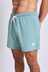 Short de baño azul con logo blanco en la pierna izquierda.