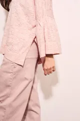 Sweater rosa con mangas acampanadas y cuello redondo. Tejido suave y confortable de algodón, acrílico y lino.