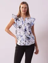 Blusa de algodón estampada con flores en tonos celeste y azul, cuello mao, escote en V, abertura frontal con botones y volados en las sisas.