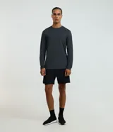 Remera deportiva de manga larga para hombre, color gris azulado jaspeado, con cuello redondo y costuras visibles en hombros y cuello.