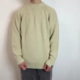 Sweater color crema de tejido grueso con cuello redondo y corte oversize.