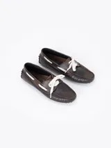 Mocasín Lyon de cuero vacuno color rosado con efecto gastado. Presenta detalles de picado en los laterales y la capellada, y se ajusta con cordones de encaje blancos. Suela de goma.