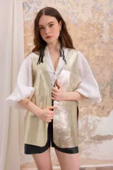 Chaleco dorado de cuero vacuno descarne, de corte recto con aberturas inferiores en los laterales y en el frente.