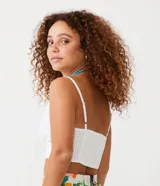 Blusa cropped blanca de laise con escote en pico, tirantes finos y bajo ancho.