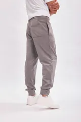 Pantalón deportivo tipo jogger color gris con cintura elástica y cordón ajustable.